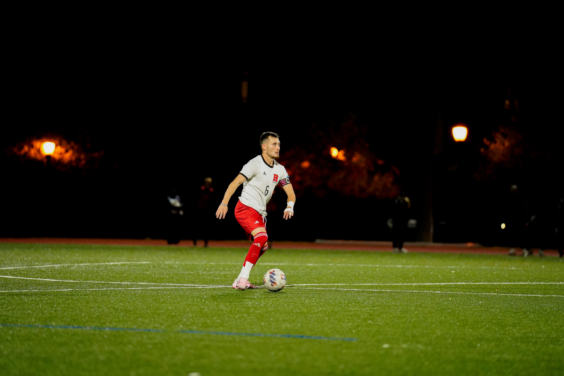 Soccer player striking the ball at sunset